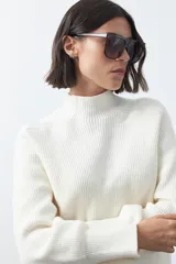 Polera de tejido de punto en color marrón oscuro, con cuello alto y diseño de silueta relajada.