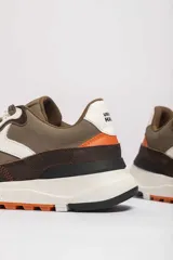 Zapatillas deportivas color crema con detalles en beige, negro y blanco.