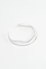 Gargantilla rígida de diseño minimalista compuesta por dos aros metálicos de diferentes grosores y formas, uno liso y otro con una ligera ondulación.