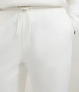 Pantalón jogger de corte holgado con cintura elástica y cordón ajustable. Presenta bolsillos laterales y puños elásticos en los tobillos.