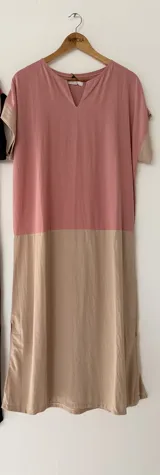 Vestido largo oversize en combinación de colores tostado y negro, con escote en V, mangas cortas y bolsillos laterales.