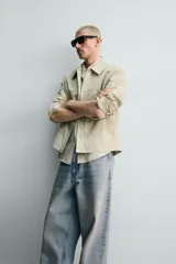Sobrecamisa de corte regular fit en color beige, confeccionada en popelín de algodón. Cuenta con cuello solapa, manga larga con puño abotonado, bolsillos ocultos en las costuras de la cadera y cierre frontal con botonadura oculta.