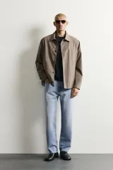 Pantalón de jean corte slim fit con efecto lavado, tiro medio, cinco bolsillos y cierre frontal con cremallera y botón.