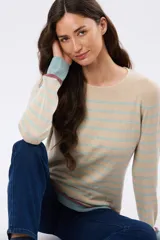 Buzo tejido a rayas de algodón, con cuello redondo y mangas largas. Las franjas combinan tonos beige, celeste y detalles en bordo.
