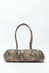 Cartera baguette cilíndrica con estampado de piel de serpiente en tonos beige y negro. Asas cortas y cierre superior con cremallera.