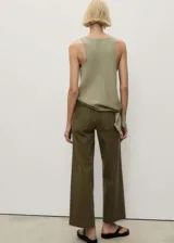 Pantalón de jean color verde oliva, de corte wide leg, tiro alto y largo al tobillo. Tiene bolsillos de parche delanteros y traseros, trabillas para cinturón y cierre frontal con cremallera y botón.