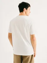 Remera de corte regular color beige con cuello redondo, mangas cortas y estampa frontal de pequeños nudos marineros en tono azul.