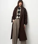 Trench coat largo color marrón chocolate, confeccionado en tejido tipo paño, con solapas amplias, cierre frontal cruzado con cinturón de la misma tela para anudar y detalles de trabillas en los hombros y puños.