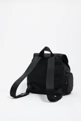 Mochila mediana de nylon negro con estructura blanda, cierre de solapa con mosquetón y cordón ajustable. Cuenta con bolsillos laterales con cierre, asa superior y logo metálico de la marca en el frente.