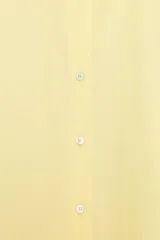 Camisa de popelín color rosa pálido, con cuello solapa, escote pico y manga larga terminada en puño. Cierre frontal con botones.