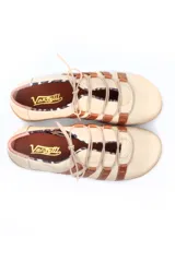 Zapato deportivo casual de cuero, con diseño de tiras laterales en contraste color marrón sobre base color crema. Presenta cierre con cordones y suela de goma con relieve.