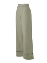 Pantalón de corte recto y tiro alto, confeccionado en una mezcla de lino orgánico y viscosa. Presenta detalles de calado decorativo en la cintura y en el ruedo de las piernas.