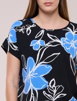 Blusa de silueta holgada y recta, confeccionada en crepe de poliéster con estampado animal print. Presenta escote redondo clásico, mangas cortas de hombro caído con puño doblado y ruedo ligeramente curvo.