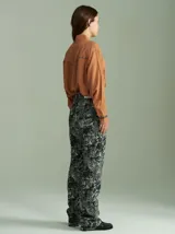 Camisa negra de algodón con mangas largas, cuello camisero y detalles de ribetes estampados a cuadros en los hombros, puños y aberturas de botones.
