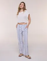 Pantalón de pierna recta y silueta amplia, confeccionado en mezcla de lino y rayón, con diseño a rayas en tonos celestes y blancos. Cuenta con cintura elastizada fruncida, cordón ajustable al frente y bolsillos laterales.