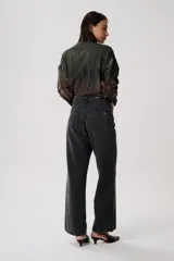 Jean baggy de tiro medio en denim claro, con estructura relajada y pierna ancha. Presenta costuras visibles y diseño clásico de cinco bolsillos.