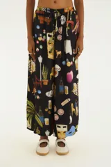 Pantalón negro de calce amplio y recto, confeccionado en viscosa liviana. Presenta una estampa colorida con ilustraciones estilo collage urbano, cintura elástica con cordón de ajuste y diseño fluido.