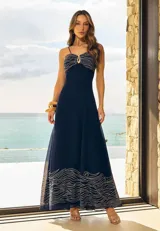 Vestido largo azul marino de tirantes, confeccionado con detalles bordados en tono claro en el escote y en el ruedo. Presenta una argolla metálica en el centro del busto y una falda fluida de corte evasé.