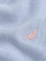 Camisa Club House de lino color blanco, corte slim fit con cuello Hudson, manga larga y detalle de bordado de pájaro azul en el pecho.