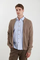 Cardigan de tejido de punto con cierre frontal completo, cuello redondo y bolsillos laterales. Presenta un diseño de textura acanalada y puños elásticos.