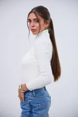 Polera blanca de cuello alto, manga larga y tejido acanalado.