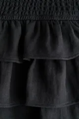 Short pollera de sarga de mezcla de viscosa, color negro, con cintura ancha fruncida y diseño escalonado de volados.