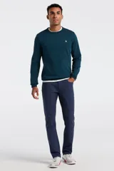 Buzo de cuello redondo en color azul petróleo, confeccionado en tejido de punto fino. Presenta puños y ruedo acanalados, con el logo de la marca bordado en el pecho.