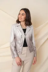 Chaqueta plateada de cuero ecológico con efecto degradado. Modelo corto con cierre frontal asimétrico y cuello clásico.