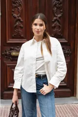 Camisa blanca de corte clásico con bolsillo en el pecho y botones al tono. Confeccionada en tejido suave de algodón y spandex.