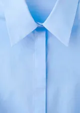 Camisa de popelina celeste, de silueta slim, manga larga y cuello camisero.