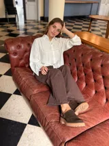 Zueco de cuero color chocolate con diseño cerrado en la parte frontal y suela de goma con plataforma baja.