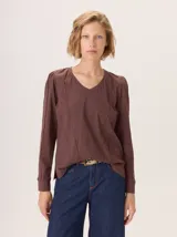 Remera de manga larga color marrón oscuro con cuello en V y detalles de costuras curvas (alforzas) en el frente y mangas.