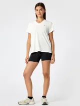 Remera deportiva de manga corta y cuello en V color blanco, confeccionada con tecnología Aircool. Presenta un pequeño logo reflectante en el pecho.