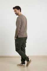 Pantalón cargo negro con bolsillos laterales con fuelle y corte recto.