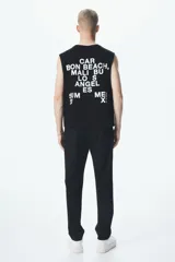 Pantalón negro de tela con corte slim fit, cierre y botón, bolsillos laterales y bolsillo insertado atrás.