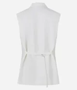 Chaleco largo de sastrería color blanco, con solapas tipo peaked, cierre frontal oculto y ajuste mediante lazo con hebilla en la espalda.