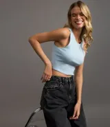 Top cropped sin mangas, color marrón oscuro, de corte ajustado al cuerpo y cuello redondo. Presenta textura acanalada.