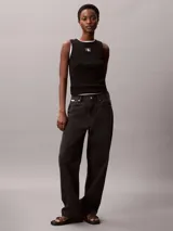 Musculosa Calvin Klein de corte slim confeccionada en tejido de canalé de algodón con elastano. Presenta cuello redondo, tirantes anchos y una etiqueta con el monograma CK en el centro del pecho.