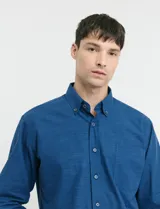 Camisa de manga larga con cuello button-down, cierre frontal con botones y bolsillo parche en el pecho. Presenta un diseño de textura sutil en color azul.