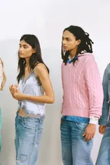 Top satinado color celeste con escote en pico y tirantes finos. Presenta detalles de encaje gris en el escote y el bajo, y una cintura ajustable con lazada.