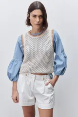 Short de tiro alto confeccionado en algodón, con calce relajado y silueta recta. Presenta pinzas delanteras, bolsillos laterales y botones decorativos en la cintura.