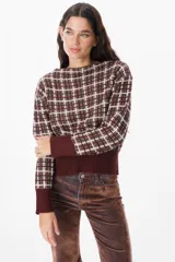 Sweater de punto con diseño de cuadros en tonos bordeaux y chocolate, cuello redondo y puños y ruedo acanalados.