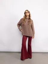 Sweater de punto con diseño de trenzas verticales, cuello alto y silueta oversize. Presenta un patrón bicolor en tonos azul y azul oscuro, con mangas largas y terminaciones en tejido acanalado.