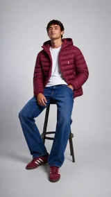 Campera puffer con capucha, diseño acolchado horizontal, cierre frontal y logo bordado en el pecho.