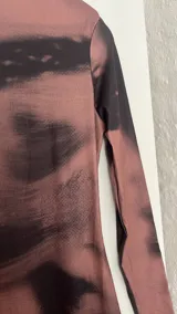 Vestido midi marrón con estampado abstracto en negro, de corte ajustado y manga larga.