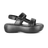 Sandalias negras con plataforma, tiras anchas de cuero sintético y ajuste con hebilla en el tobillo.