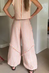 Babucha de lino blanca con rayas celestes, de pierna amplia, corte relajado y detalles de flecos. Confeccionada con tejido fresco y ligero, cuenta con botamangas ajustadas.