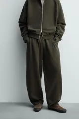Pantalón jogger de algodón color verde oscuro, con efecto lavado, corte balloon fit y cintura elástica. Presenta bolsillos delanteros y bolsillos traseros de plastrón.