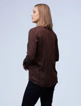Camisa de manga larga con estampado a rayas verticales marrones y negras. Tiene cuello con solapa, abertura central con botones y bolsillo en el pecho.