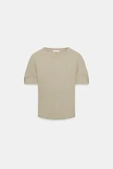 Camiseta de manga corta confeccionada en hilatura con mezcla de algodón, con diseño de tejido en rib y corte slim fit. Presenta cuello redondo y costuras verticales decorativas en el frente.
